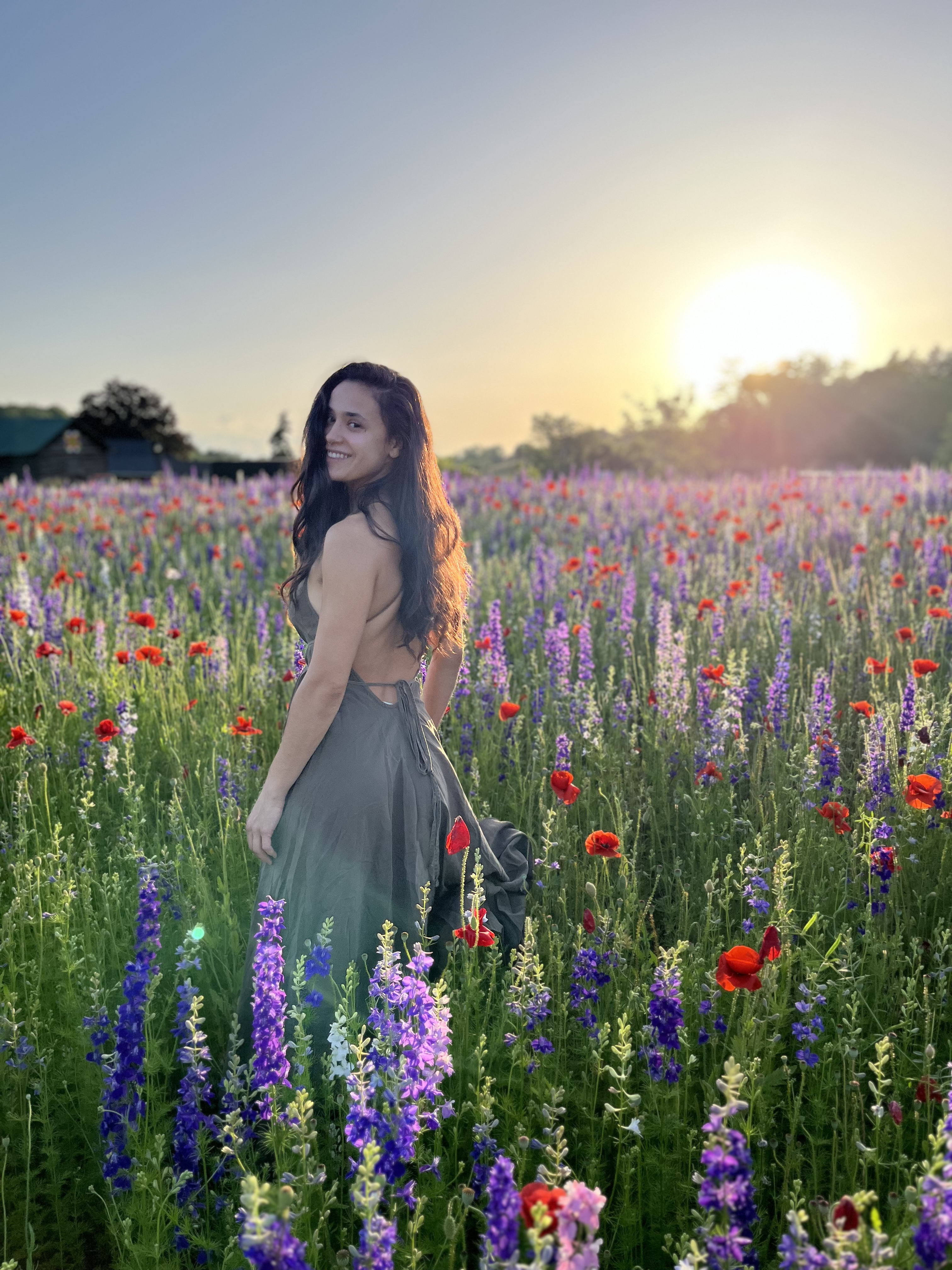 Photo of Hannah Procell standing in a field of flowers.